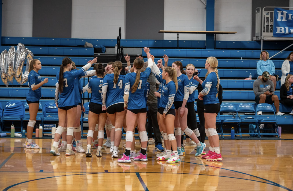 The Highlands Varsity Volleyball team huddles and cheers before taking the court.